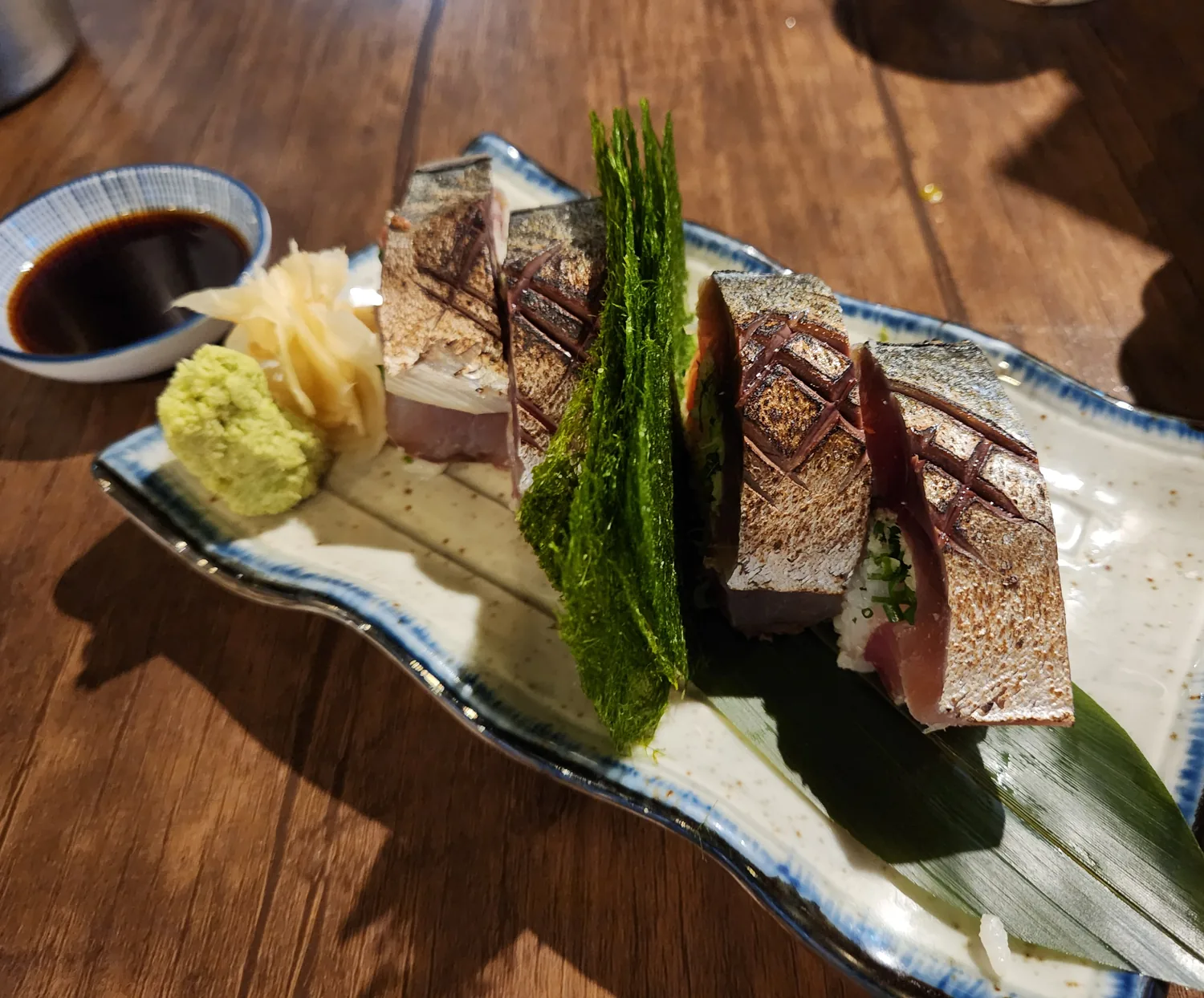 Torched mackerel sushi (saba) on seasoned rice with seaweed at Enwoo