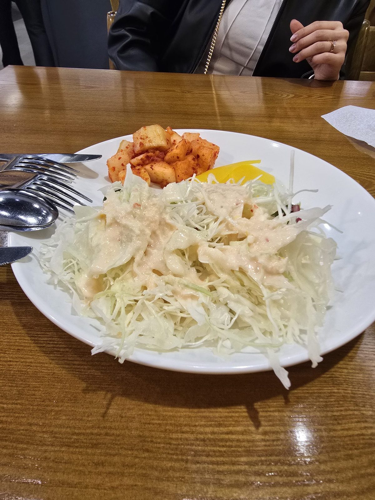Plate of fresh coleslaw with creamy dressing, kkakdugi, and danmuji