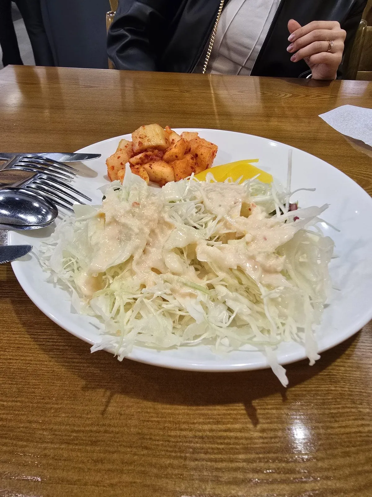 Plate of fresh coleslaw with creamy dressing, kkakdugi, and danmuji
