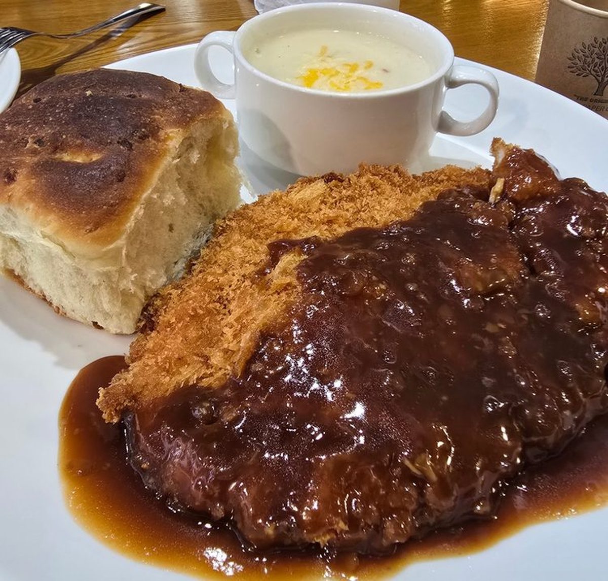 Korean-style donkatsu with rich demi-glace sauce, cream soup, and freshly baked bread at Evergreen in Indeogwon, Anyang