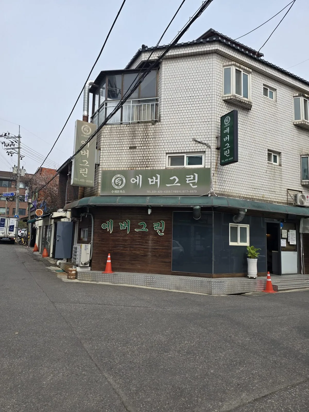 Exterior of Evergreen donkatsu restaurant — a modest corner building with green signage in a quiet Indeogwon neighborhood
