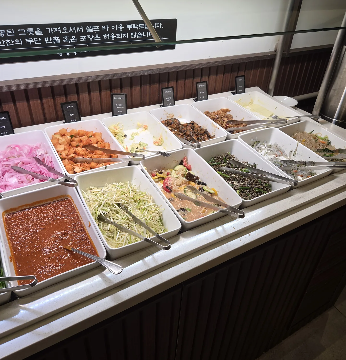 Close-up of banchan trays — pickled onions, kkakdugi, salads at Gwangneung Ok