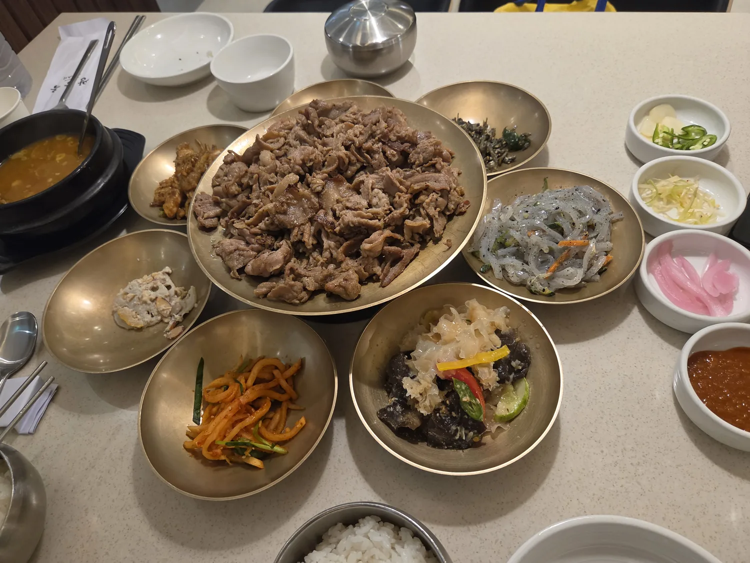 Full banchan table with jelly noodles, sauces, and pickles at Gwangneung Ok