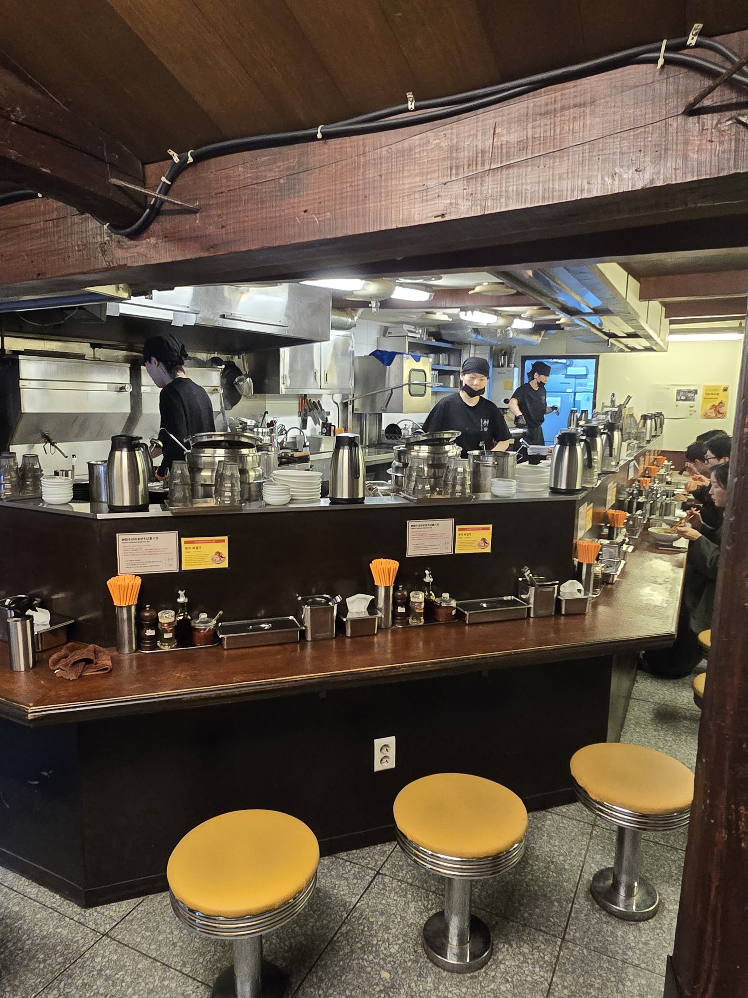 Open kitchen counter at Kanda Soba with yellow stools