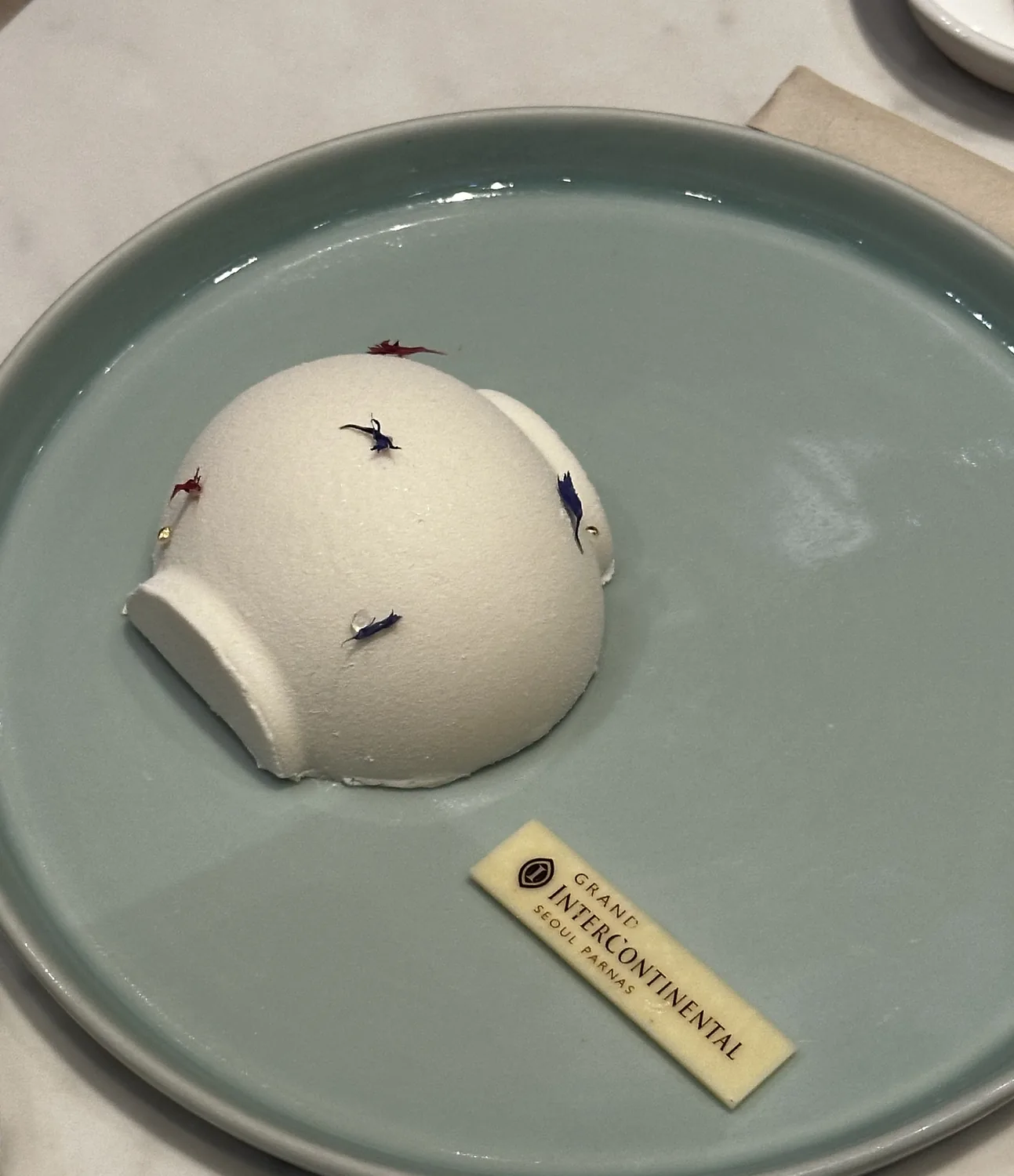 Moon jar (dalhangari) shaped white cake with cornflower petals at InterContinental Parnas